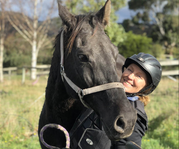 Annette Kaitinis posing with her black horse Matty in Tasmania 